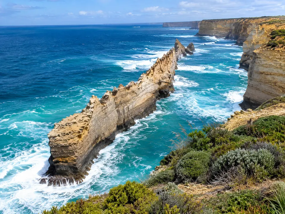 A long, thin limestone ridge rising out of the sea below the cliffs